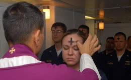 Electronics Technician 3rd Class Leila Tardieu receives the sacramental ashes during an Ash Wednesday celebration aboard the amphibious assault ship USS Wasp (LHD 1).